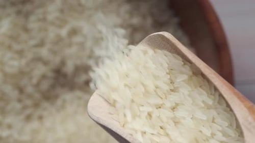 Pouring White Rice with Wooden Spoon Close Up