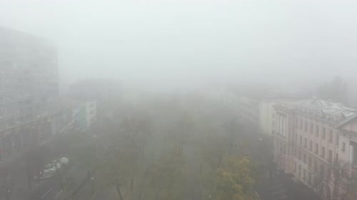 Foggy City Street with Silhouettes of Residential Buildings
