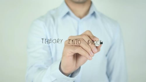 Man Writes "Theory into Practice" on Glass