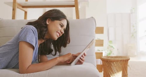 Young Woman Using Tablet on Couch at Home