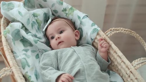 Cute Infant Lying in Bassinet with Floral Blanket