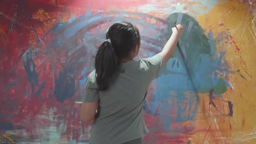 Child Paints Abstract Artwork on Canvas in Studio