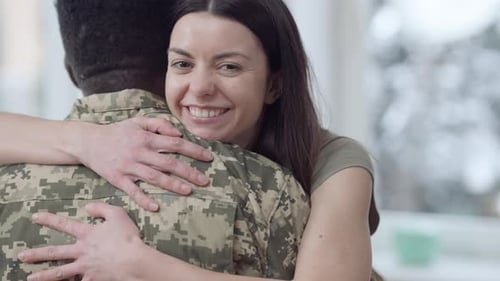 Woman Embracing Soldier Lovingly in Home Interior
