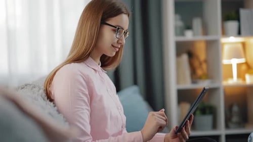 Woman Using Tablet on Couch at Home