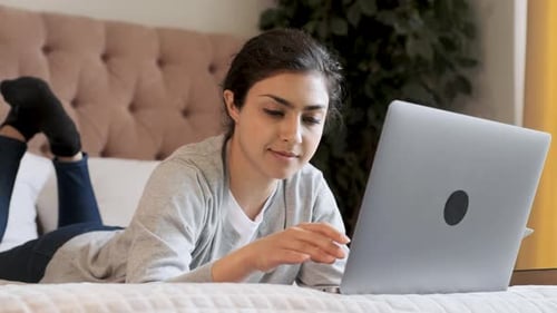 Nahaufnahme Eine junge indische, nachdenkliche Frau tippt auf einer Tastatur und arbeitet online