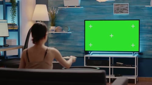 Mujer caucásica mirando televisión de pantalla verde