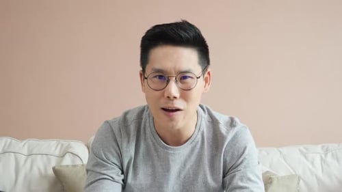 Friendly Man Speaking to Camera on Couch