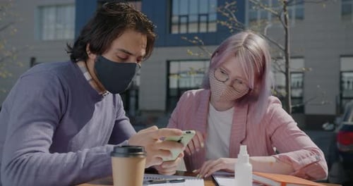 Businesspeople Working in Street Cafe Using Smart Phone Talking Wearing Masks