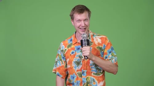 Young Handsome Tourist Man Talking on Microphone and Showing Something
