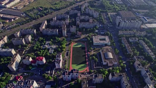 Buildings with Street in Small Town with Empty Football Soccer Field