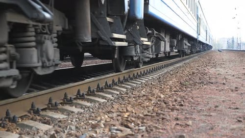 Close Up Spinning Steel Wheels of the Train Moving Along the Rail Track. Passenger Railway Transport