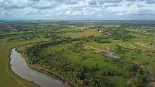 Flug über grüne Wiese und Fluss im Frühling