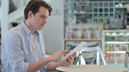 Attractive Creative Man Using Tablet in Cafe