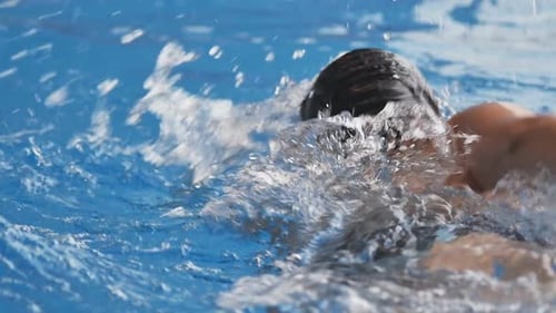 Closeup a Teenage Swimmer Swims Breaststroke in the Pool