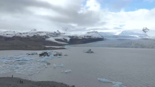 Aerial Panning Shot of a Glacial Lagoon Filled with Icebergs.