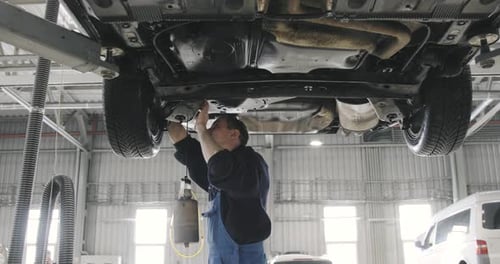 Auto Mechanic Repairing Car in Garage
