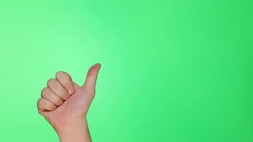 Thumb, well, good sign. Closeup of male hand isolated on green screen background