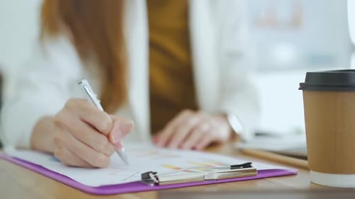 Woman Reviews Data Report in Bright Office