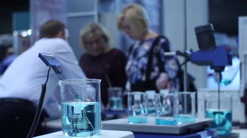 Beakers with blue liquid in lab setting