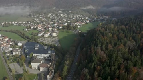aerial view of a car driving towards a village in the countryside. DJI Mavic