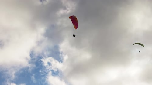 Die Leute versuchen Paragliding mit Fallschirmen gegen Wolken zu fliegen