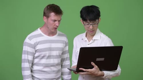 Two Men Look at Laptop, One is Upset