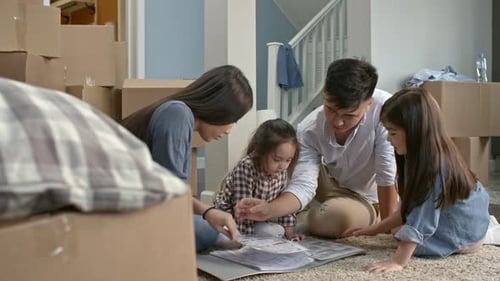 Family Looking at Floor Plans in New Home
