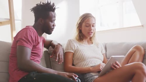 Couple Using a Tablet on Sofa at Home