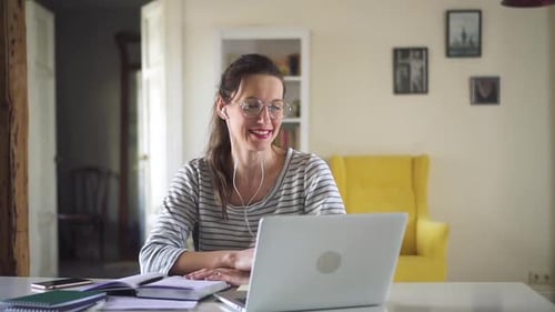 Woman Conducts Video Call on Laptop at Home