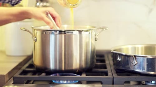 Woman cooking with pots and pans on a stove