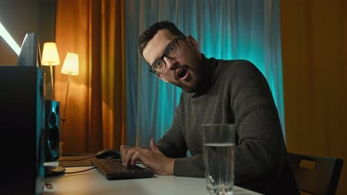 Man Working on Computer at Desk at Night