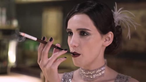 Portrait of a Young Attractive Woman in a 1920s Style Smoke Cigarette at the Bar