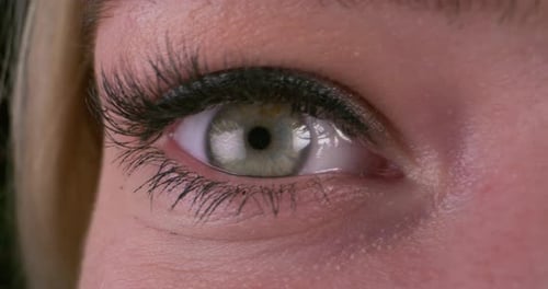 Frau trägt Mascara mit Pinsel auf