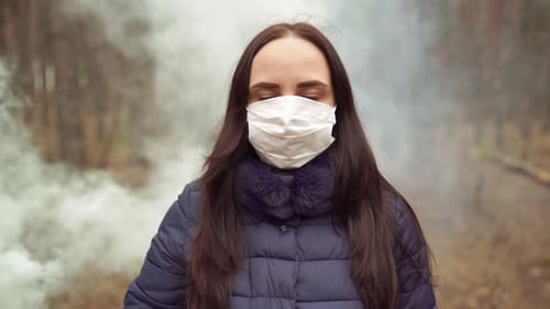 Portrait of Young Woman in Medical Mask on Her Face in Forest