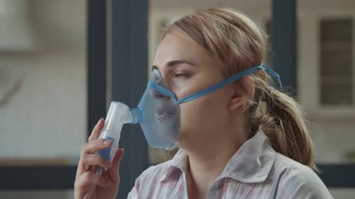 Femme utilisant un nébuliseur pour les maladies respiratoires intérieures