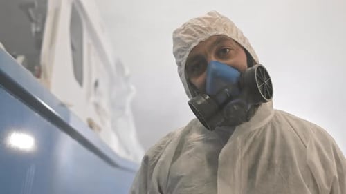 Worker with Respirator Using Spray Gun
