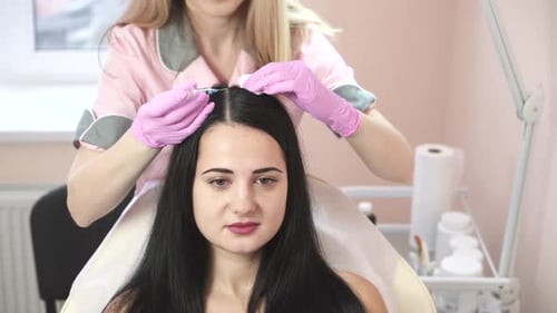 Mésothérapie à aiguilles. Le cosmétologue fait des injections dans la tête de la femme.