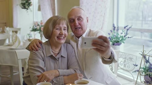 Senior Couple Taking Selfie in Cafe