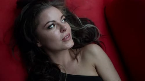 Smiling Woman Lying on a Red Surface