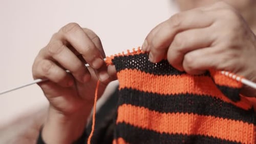 Close up of knit work tie-up hand work. Woman's hands knitting with black and red wool