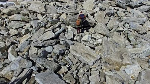 Aerial of Couple Climbing Rocky Mound