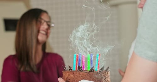 Woman Blows Out Birthday Candles with Friends