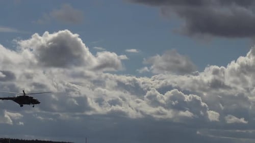 Helicopter Flying Through Cloudy Blue Sky