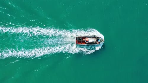 Aerial Footage of a Boat Carrying Load Within Turquoise Ocean Waters