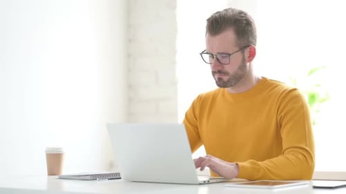 Man Showing Thumbs Up Sign While Using Laptop in Office