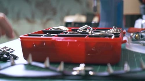 Hands Sorting Hardware Pieces in Toolbox Close Up