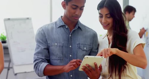 Man and Woman Collaborating With a Tablet in Office