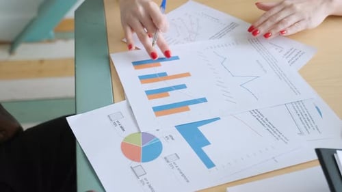 Gruppe unkenntlicher Geschäftsleute analysiert Statistiken, Grafiken und Diagramme