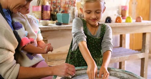 Girl Shaping Clay with Family at Home