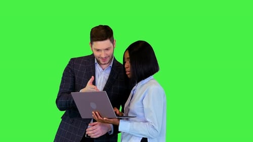 Two Adults Reviewing Laptop on Green Screen